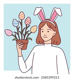 A teenage girl wearing bunny ears holds a plant with Easter egg decorations, smiling warmly.