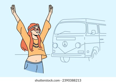 Teenage hippie girl goes on summer travel in minivan and raises hands, rejoicing at opportunity to relax. Young hippie woman standing near tourist van for travel with pacifism symbol
