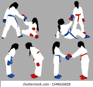 Teenage karate girls in white kimonos and blue and red outfits help each other out in training and show respect before the fight.