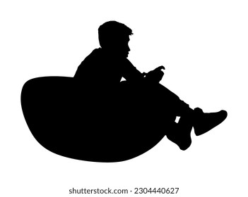 Teenager gamer boy playing video game and watching screen monitor vector silhouette illustration isolated on white background. Kid with joystick on lazy bed enjoying. Children entertainment shape. 