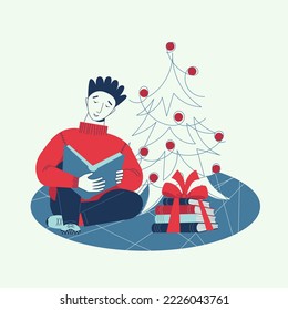 Teenager reading a book next to the Christmas tree