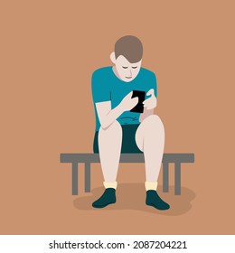 A teenager in shorts and a blue shirt sits and bent over a gadget and holds a smartphone in his hands. Concept of modern youth and virtual world in cartoon flat style.