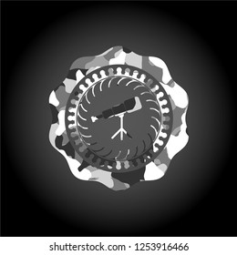 telescope icon inside grey camo emblem