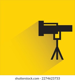 telescopio con sombra sobre fondo amarillo