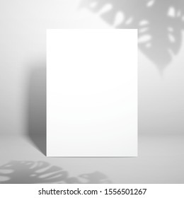 Template for design with white blank sheet of paper and shadows from the leaves of the monstera plant