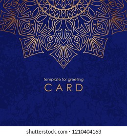 Template greeting card. Round gold mandala on blue background with texture and inscription.