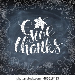 Template vector card. Handwritten chalk calligraphy inscription Give Thanks with maple leaf.   Hand drawn linear vegetables on blackboard. Food background.