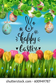 Template vector card with realistic colorful eggs, grass and tulips. Handwriting inscription Happy Easter and bunny. Sunny green background. Lettering, calligraphy. 3D. Decorated eggs hang on a tree.