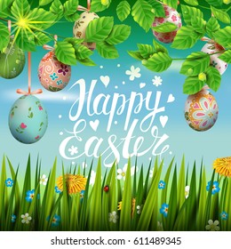 Template vector card with realistic colorful eggs, grass and flowers. Handwriting inscription Happy Easter. Bright sunny green background.  Foliage. Calligraphy. 3D. Decorated eggs hang on a tree.