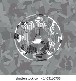 test tube icon inside grey camouflage emblem