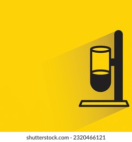 test tube on stand with shadow on yellow background