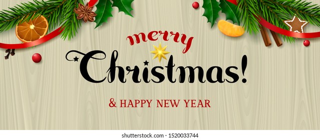 Text merry Christmas! & Happy New Year on wooden background with spruce branches, holly, red ribbon and food ingredients for mulled wine as decoration.