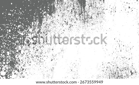 A textured background with scattered grey splatters and spots on a white surface.