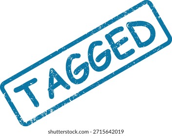 Uma impressão de carimbo azul texturizado com texto "TAGGED", orientado diagonalmente em uma superfície branca simples.