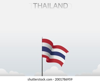 The Thai flag flutters on a pole standing tall under the white sky