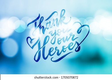 thank you our heroes, lettering on blue blurred background