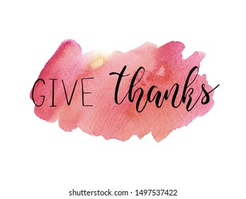 Thanksgiving Day lettering. Give thanks. Hand written Vector Design for holiday card, invitation or banner for seasonal autumn holiday. Phrase ion pink watercolor background. Fall calligraphy.