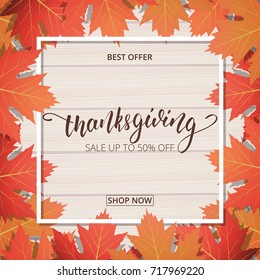 Thanksgiving Day sale banner. Hand lettering on the wooden background with trendy autumn foliage.