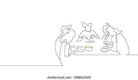 They Are Happily Eating Together At A Large Family Dinner Table.