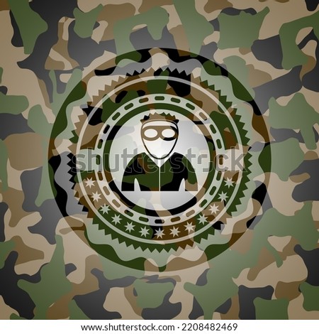thief icon inside camouflaged emblem. 