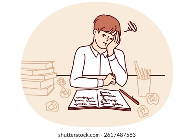 Thinking schoolboy does homework sitting at table with books and workbook after exhausting classes with tutor. Tired schoolboy from elementary school needs rest to replenish strength