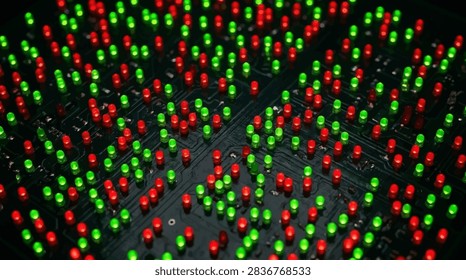 This high-angle macro shot captures a complex electronic circuit board populated with numerous small light-emitting diodes. The surface is dark and textured, providing a stark contrast to the vibrant, illuminated red and green lights scattered across the grid. The composition emphasizes the intricate patterns of the hardware, creating a futuristic and technological atmosphere through sharp focus and deep shadows