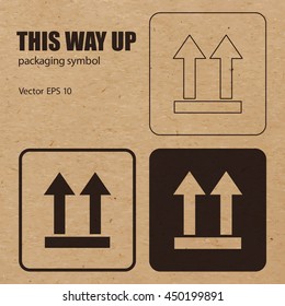 This Way Up Vector Packaging Symbol On Vector Cardboard Background. Handling Mark On Craft Paper Background. Can Be Used On A Box Or Packaging. Vector EPS 10.