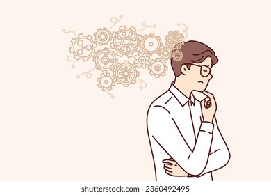 Thoughtful business man thinks about ways to automation production and improve work productivity. Guy engineer in white shirt scratches chin and thinks about possibilities of factory automation.