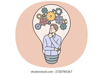 Nachdenkliche Kerl kommt mit einer neuen Idee Kratzen Kinn und Blick auf Zahnräder in Glühbirne. Intelligente Kerl entwickeln Idee, um erfolgreiche Einhorn-Startup oder Diplomarbeit für die Universität starten