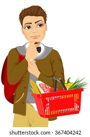 Thoughtful young man holding shopping basket full of food 