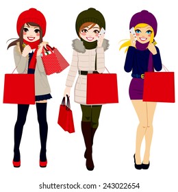 Three beautiful young women in winter clothes happy walking carrying shopping bags