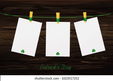 Three blank paper with green clovers hanging on a rope on a wooden clothespin. St.Patrick 's Day. Free space for your letters or advertising. Greeting card. Vector illustration on wooden background.