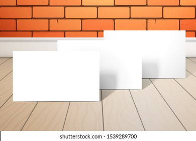 Three blank white cards stand one after another on a wooden floor. Behind a brick wall. Mockup for design with a realistic shadows