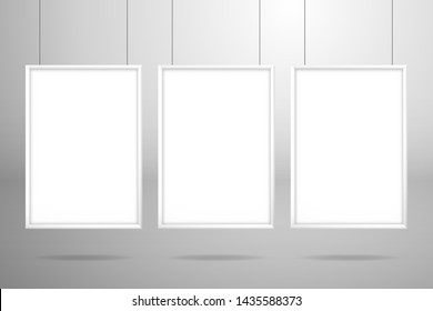 Three blank white frames hanging on the strings. Mockup for design with shadow