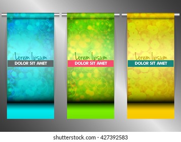 Three bright banners hanging on steel tubes.