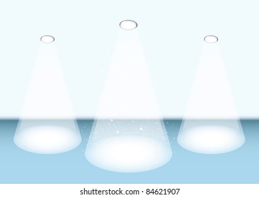 Three bright white spot lights on a blue stage for concert