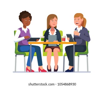 Three business woman sitting at desk together with their gadgets talking having coffee break. Woman coworkers group chatting & tapping tablet computers at meeting. Flat vector character illustration