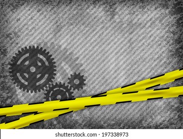 Three cogwheels on the gray grain texture with yellow tapes.