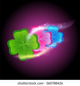 three colored clovers on the dark background