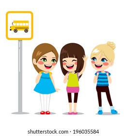 Three cute schoolgirls waiting on bus stop to ride schoolbus to school