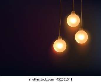 Three decorative light bulbs hanging against dark background