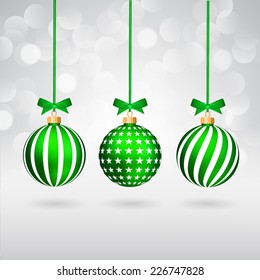 Tres diferentes bolas de Navidad decoradas con arcos sobre fondo brillante.