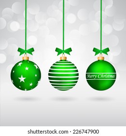 Three different decorated christmas balls with bows on sparkling background.