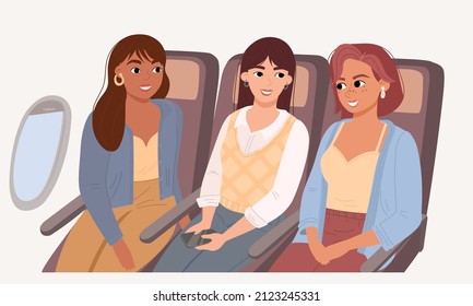 Three friends are sitting in the airplane and talking. Travel and recreation by a female group. Beautiful women with different skin colors.