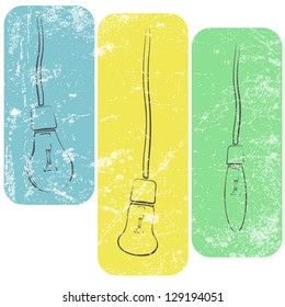 Three grunge light bulbs on wires in light colors