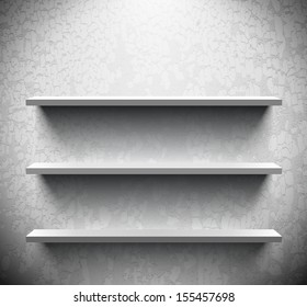 Three lightened shelves on old cracked wall