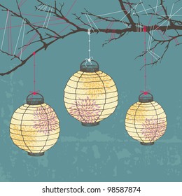 Three paper lanterns hanging on tree branch