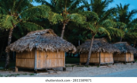 Three rustic huts with thatched roofs stand beside sandy ground surrounded by tall palm trees