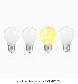 Three switched off light bulbs upside down and one light bulb alight with text - idea
