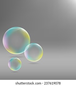 Three transparent soap bubbles with shadows on grayscale background